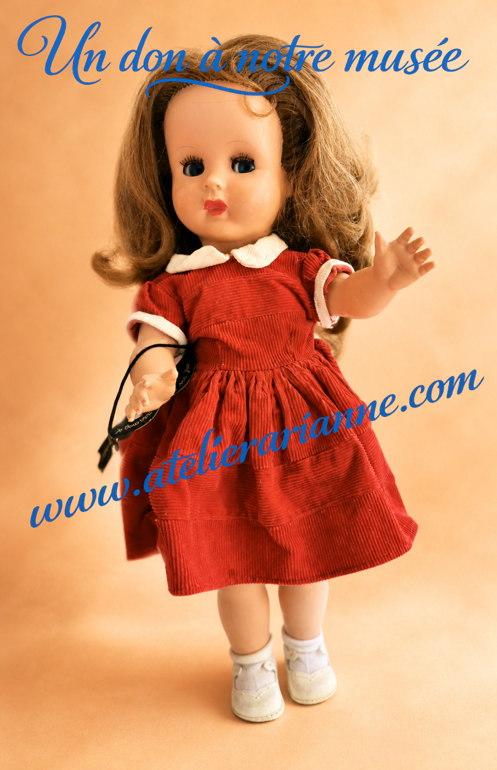 Poupée ancienne en robe rouge issue d’un don de poupées anciennes au musée Atelier Arianne, conservée comme souvenir d’enfance.