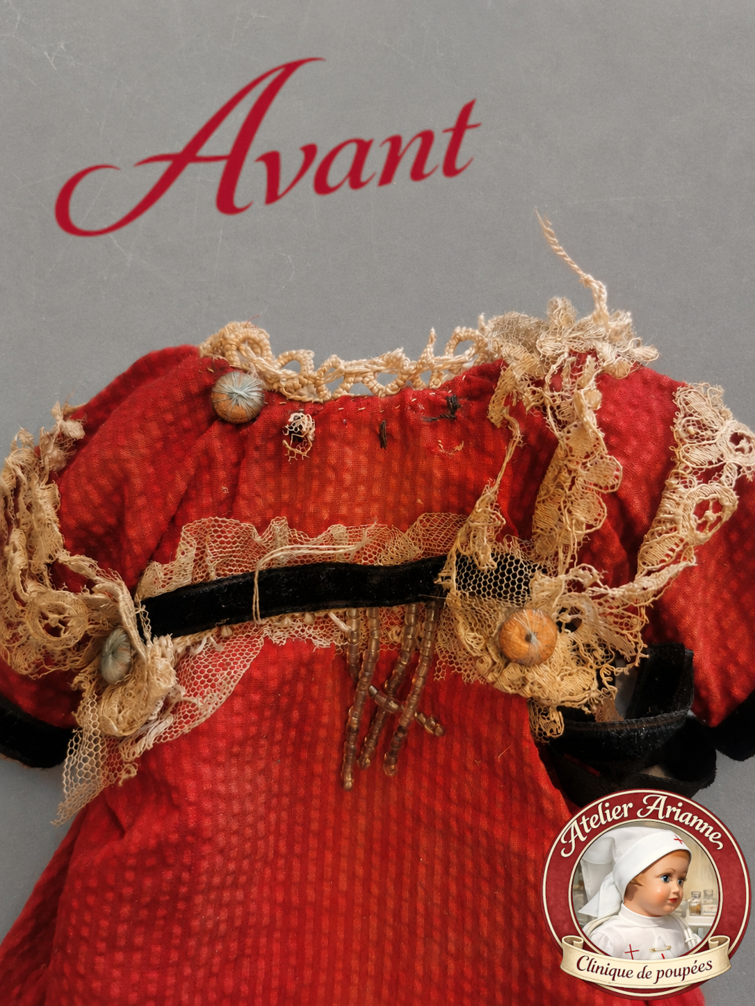 Détail avant restauration d’une tenue ancienne de poupée mignonette, montrant la dentelle brodée sur tulle très abîmée, déchirée et effilochée sur une petite robe rouge.