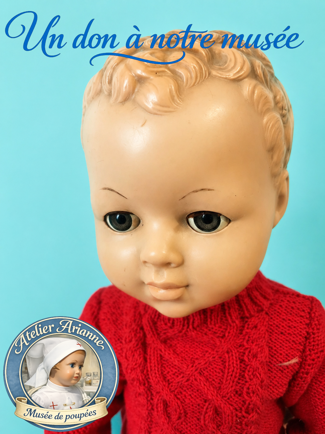 Photo du visage d&rsquo;un baigneur Adonis en poly&eacute;thyl&egrave;ne donn&eacute; au mus&eacute;e Atelier Arianne, avec cheveux moul&eacute;s, yeux dormeurs et pull rouge tricot&eacute;, destin&eacute; &agrave; documenter les poupons et baigneurs d&rsquo;enfance.