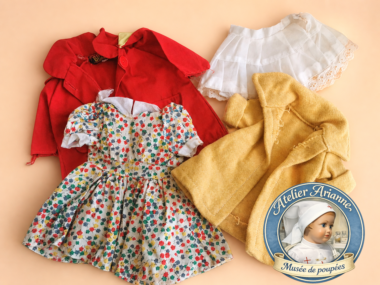 Vêtements anciens de poupées, robes, manteau et linge issus d’un don de poupées anciennes au musée Atelier Arianne.