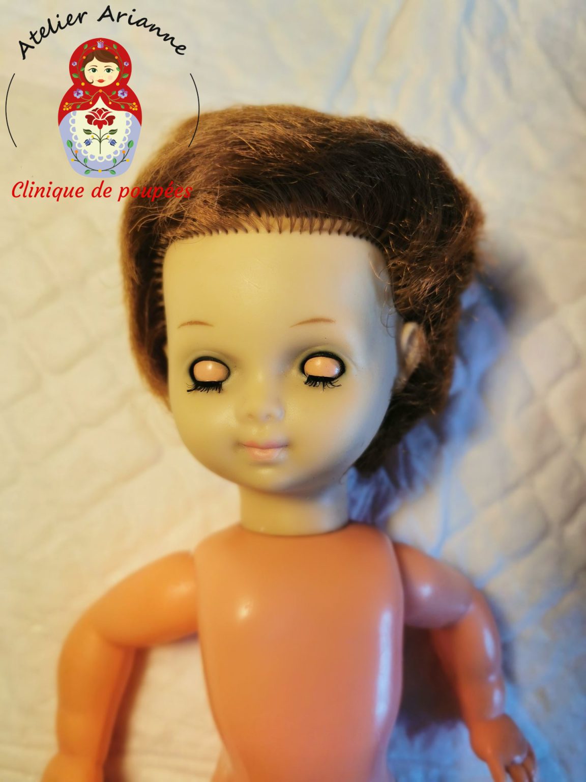 Petite poup&eacute;e Bella avant restauration, avec le visage jauni par le temps et les yeux ferm&eacute;s avant d&eacute;montage, nettoyage et remise en &eacute;tat par l&rsquo;Atelier Arianne.