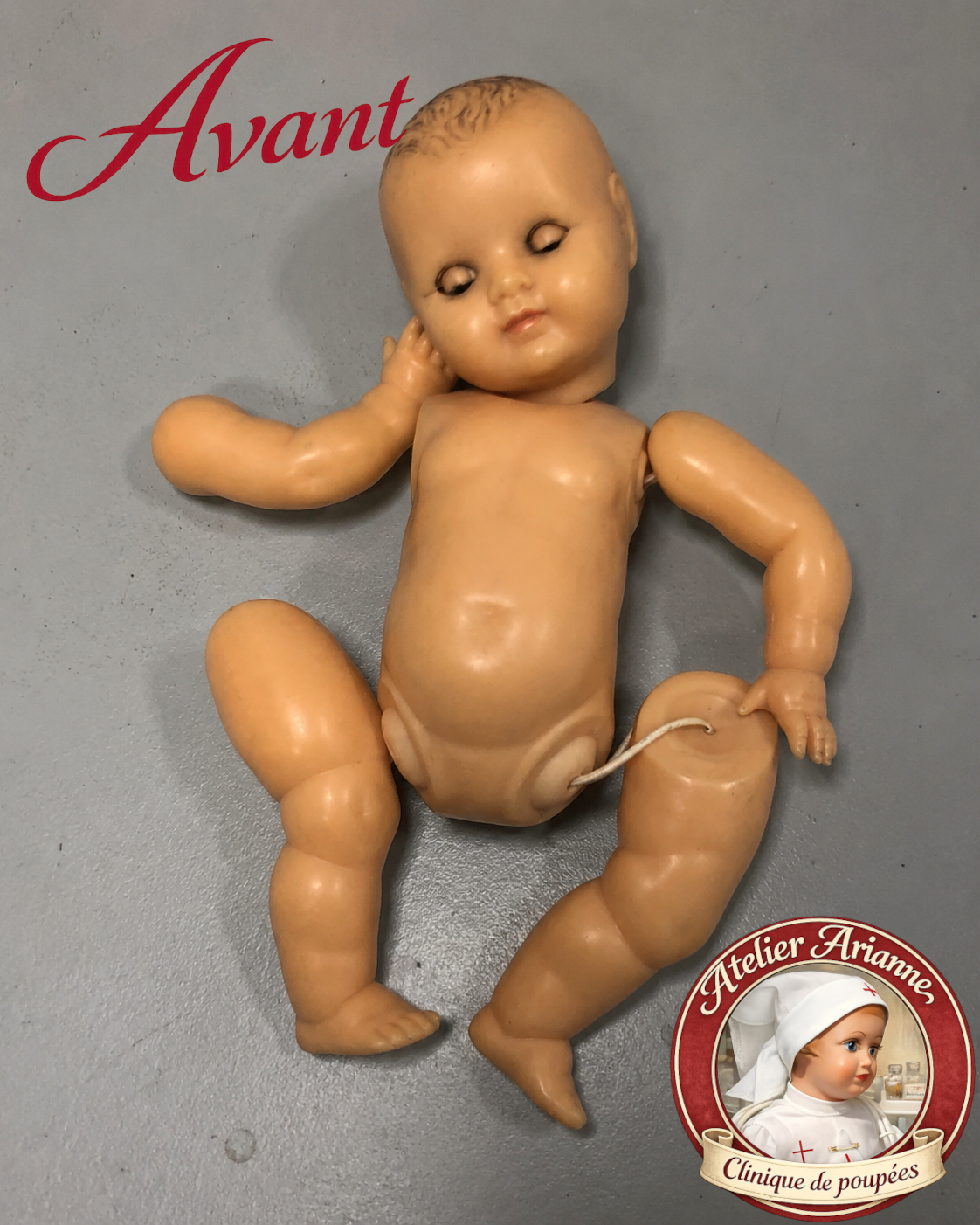 Petit Baby ancien avant restauration à la clinique de poupées Atelier Arianne, avec élastiques fatigués, visage effacé, cheveux peints ternis et yeux à lustrer.