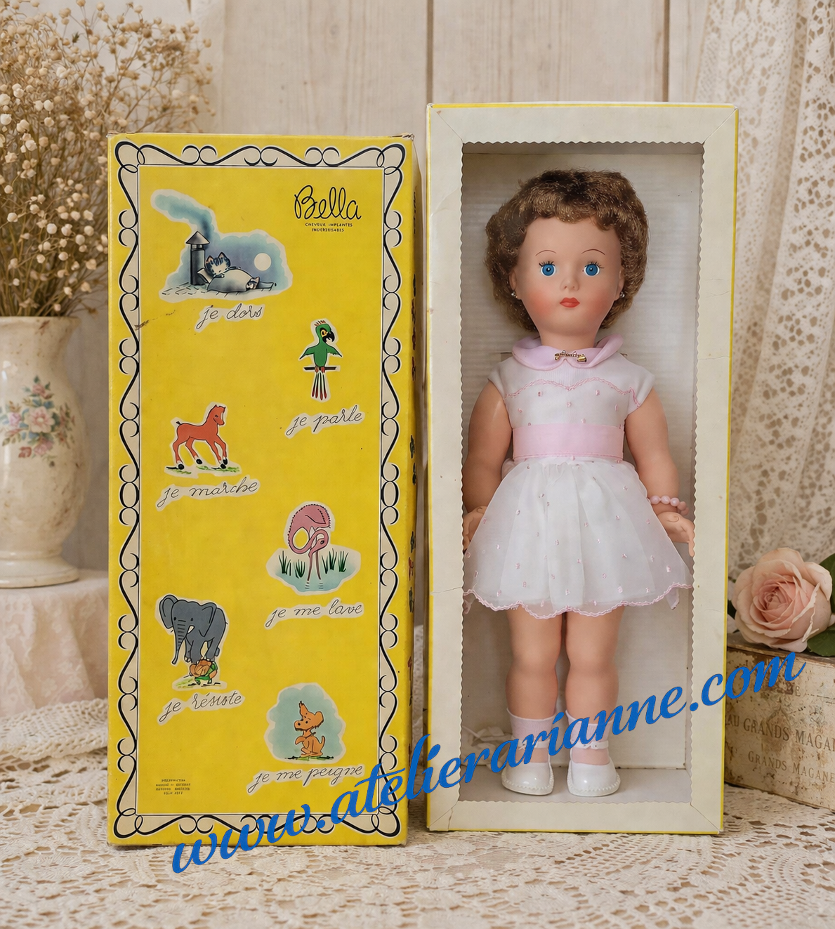 Bella M632 Christiane, grande poupée Bella des années 1960 présentée dans sa boîte jaune d’origine, avec tenue blanche et rose, cheveux implantés et étiquette M 632.