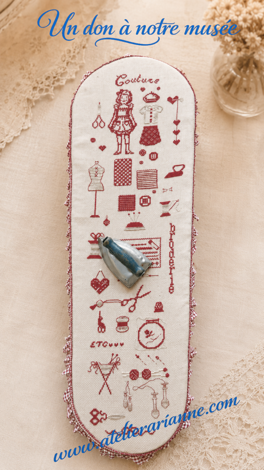 Housse de petite table &agrave; repasser d&eacute;cor&eacute;e d&rsquo;une broderie rouge au point de croix repr&eacute;sentant l&rsquo;univers de la couture : poup&eacute;e, v&ecirc;tements, ciseaux, boutons, mannequin, fils et fer &agrave; repasser. Don destin&eacute; au mus&eacute;e Atelier Arianne.